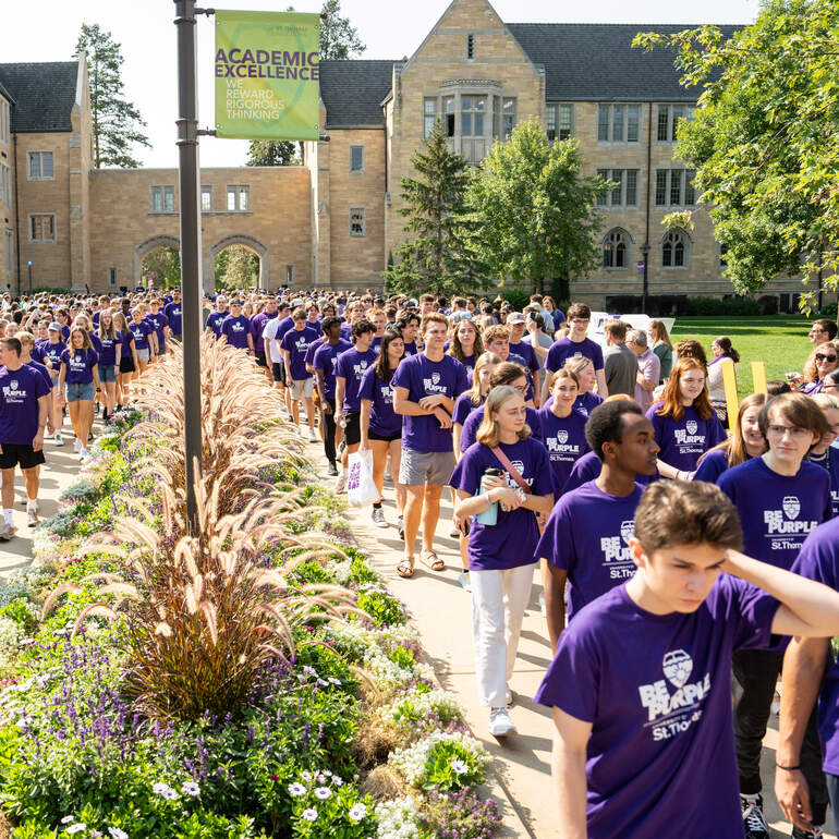 Students march through the arches